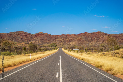 Outback road near Alice Springs with the East Macdonnell Range on the horizon. Northern Territory, Australia. photo