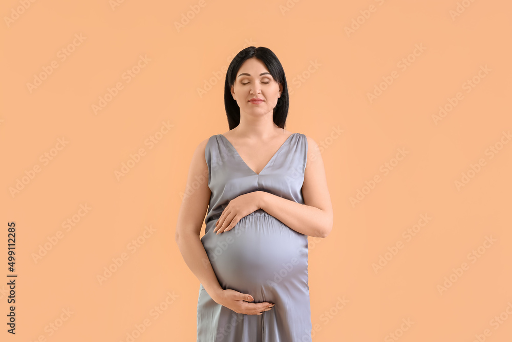 Pregnant young woman on beige background Pregnant young woman on beige background