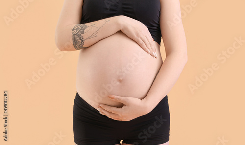 Pregnant young woman on bei...