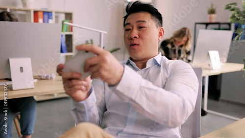 Lazy bored office worker playing mobile games in office during boring work day. Relaxation and job concept. High quality 4k footage