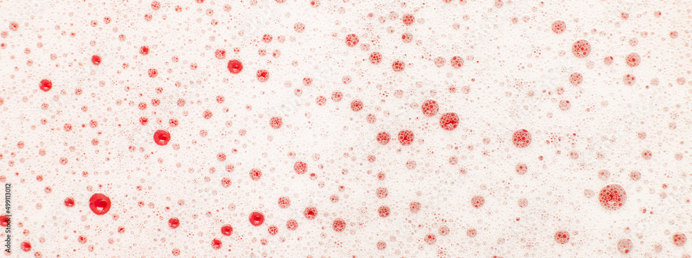 Background of red soap foam. Laundry, soap and shampoo.