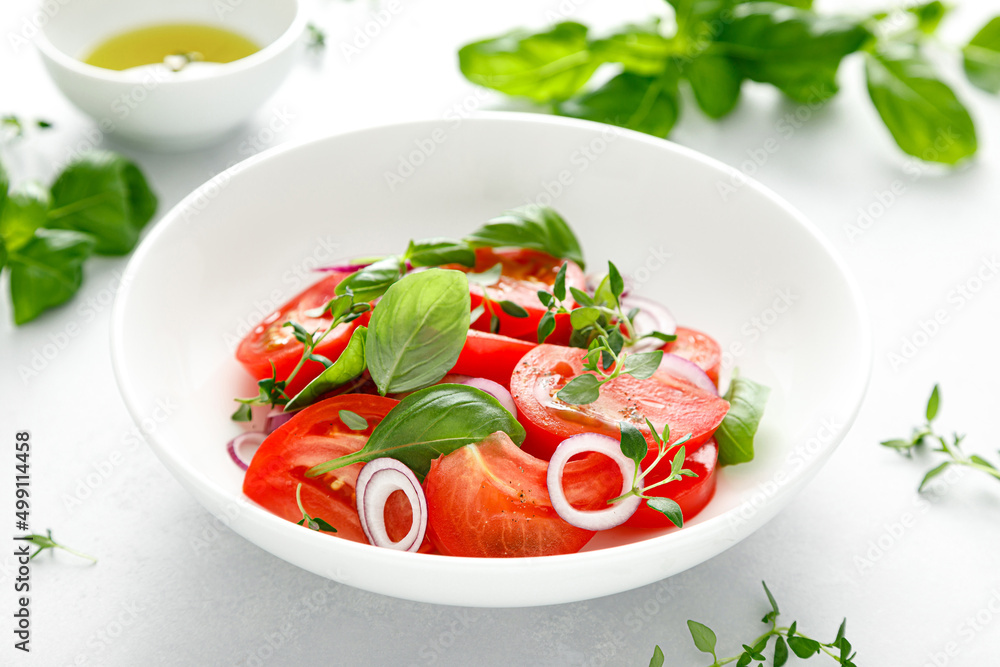 Salad with red ripe tomatoes, basil and olive oil, top view Salad with red ripe tomatoes, basil and olive oil, top view