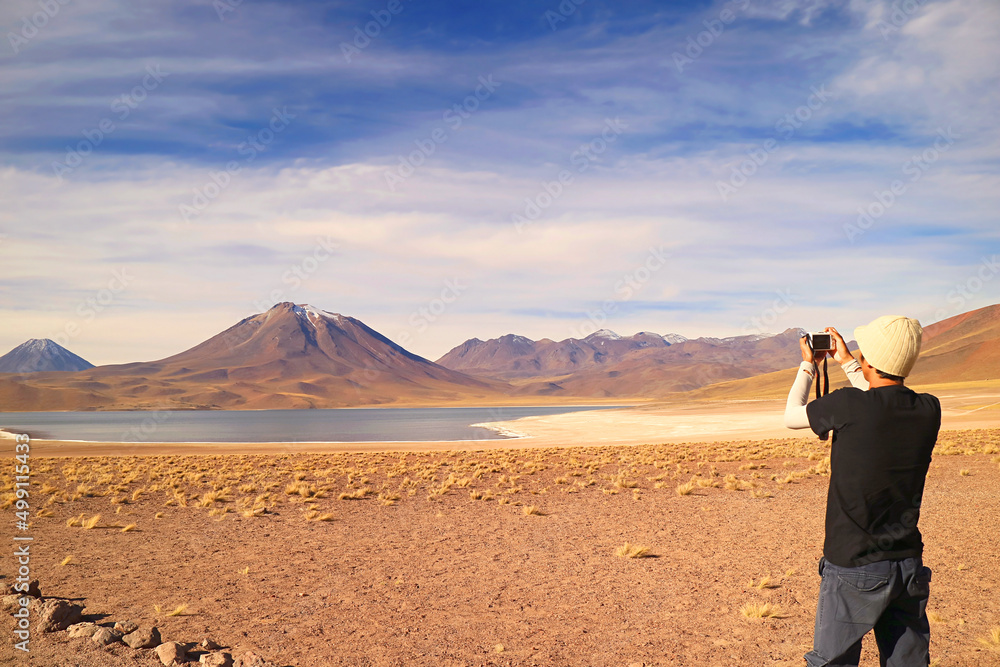 Visitor shooting photos of Miscanti lake with Mt. Cerro Miscanti in the backdrop, highland of Antofagasta region, northern Chile