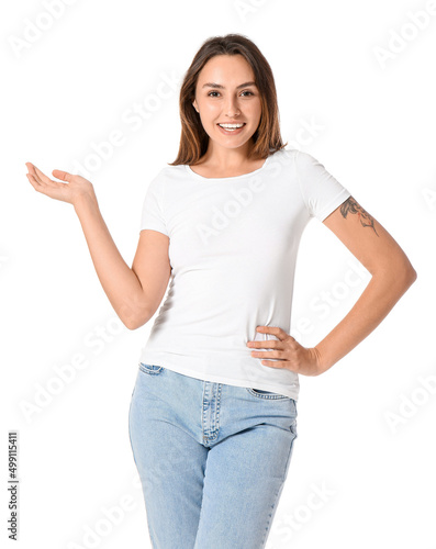 Young woman in blank t-shirt showing something on white background