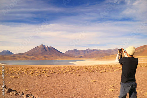 Visitor shooting photos of Miscanti lake with Mt. Cerro Miscanti in the backdrop, highland of Antofagasta region, northern Chile photo