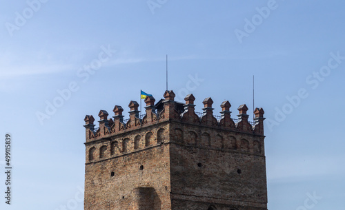 Castle tower in Ukrainian town in sunny day. Orange brick tower and blue sky. Lubart castle photo