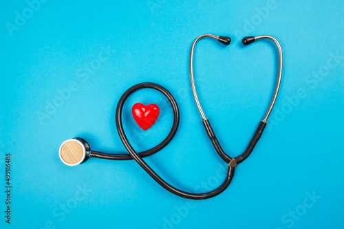 medical stethoscope and small red heart isolated on blue