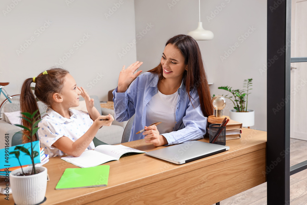 Happy little girl studying with tutor at home Happy little girl studying with tutor at home