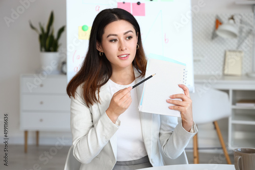 Young Asian tutor with penc...