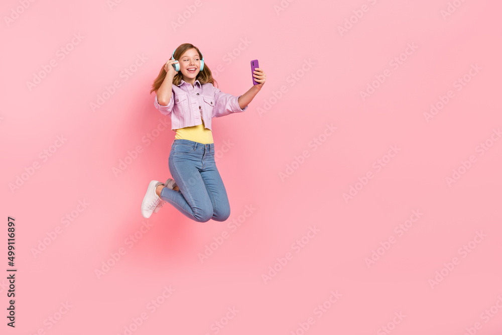 Photo of dream lady jump hold telephone search playlist wear headphones jacket jeans isolated pink color background