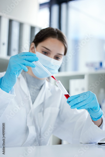 The clinical trial has gone well. Closeup shot of a young woman using a dropper and test tube while working with samples in a lab.