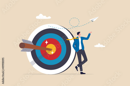 Business objective, purpose or target, goal and resolution to aim for success, aspiration and motivation to achieve goal concept, confident businessman stand with arrow hit bullseye on archery target. photo