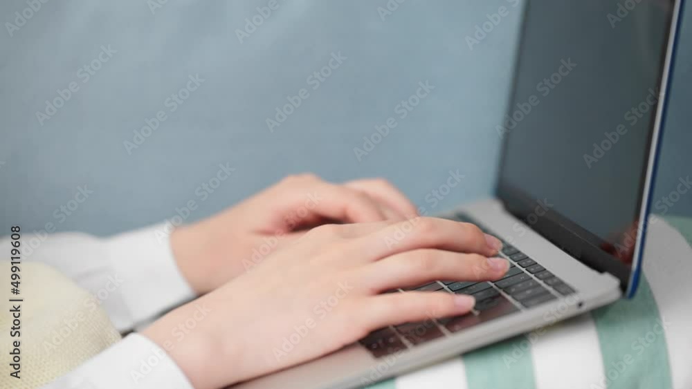ソファーでラップトップを操作している女子高生 ソファーでラップトップを操作している女子高生