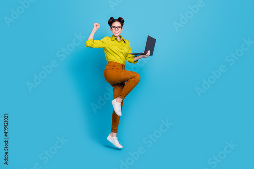 Full size photo of successful lucky lady raise fist celebrate attainment isolated on blue color background