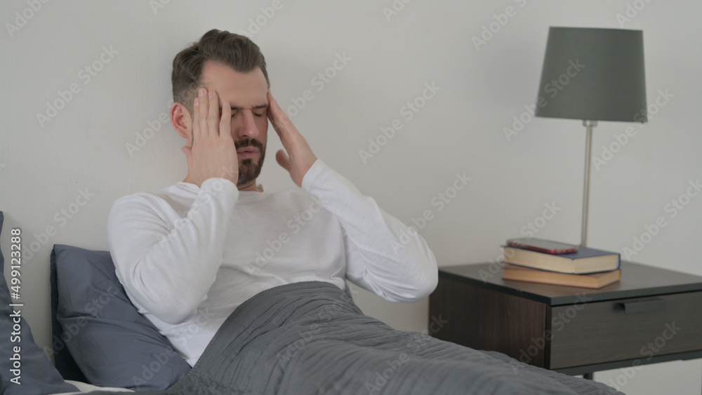 Fototapeta premium Man having Headache while Sleeping in Bed