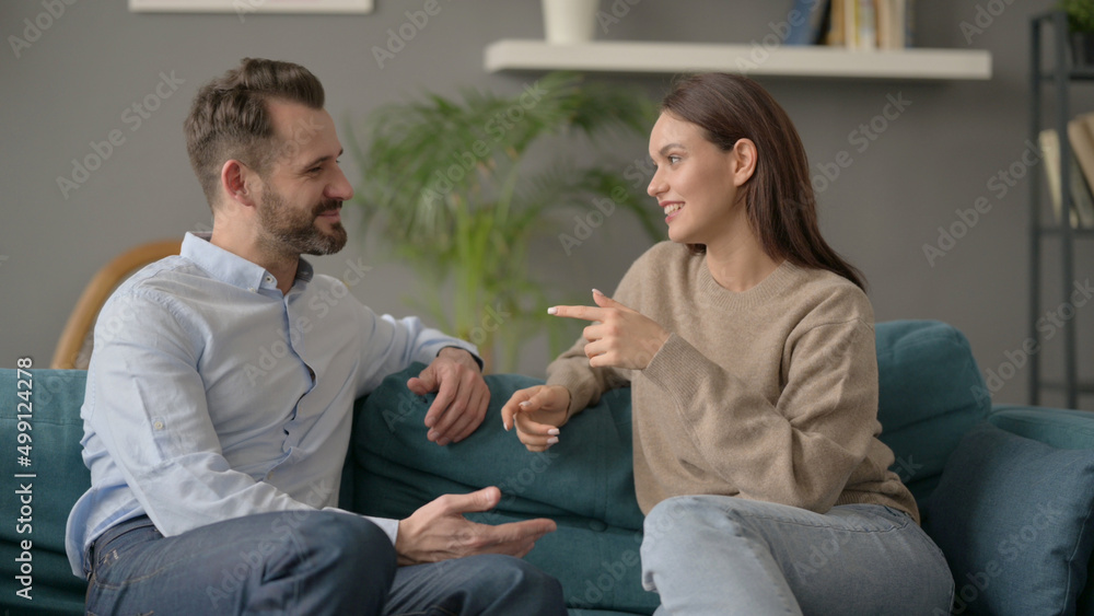 Woman Talking with Husband while Sitting on Sofa 
