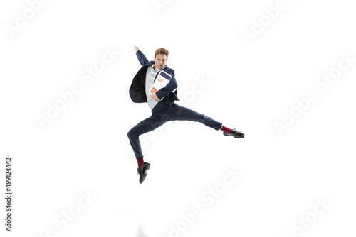 Young man in dark business suit jumping, flying isolated on white background. Art, motion, action, flexibility, inspiration concept.