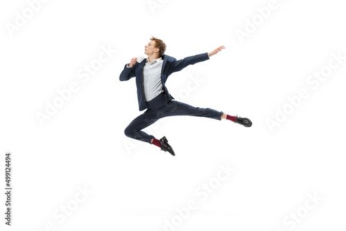 Studio shot of young male ballet dancer wearing business suit dancing isolated on white studio background. Business, start-up, art, work, caree, inspiration concept.