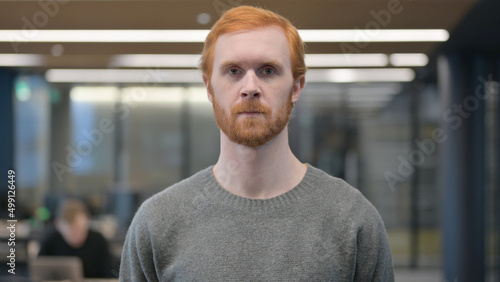 Fotografie Portrait of Serious Young Man Looking at the Camera