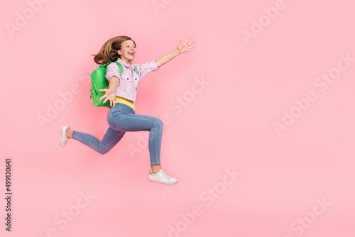 Profile photo of surprised funky lady jump catch empty space wear backpack jacket isolated pink color background