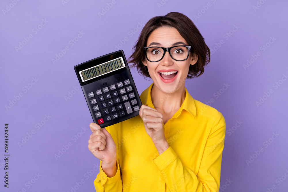 Photo of hooray millennial lady hold calculator wear yellow outfit spectacles isolated on violet color background - obrazy, fototapety, plakaty 
