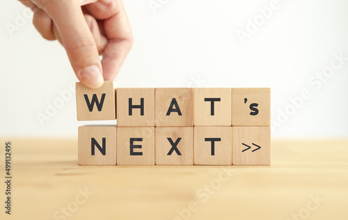 What's next?, business concept. Next step of work, plan, strategies, vision, project implementation, new opportunities and execution.  Putting wooden cubes with What's next?  and forward arrow symbols photo