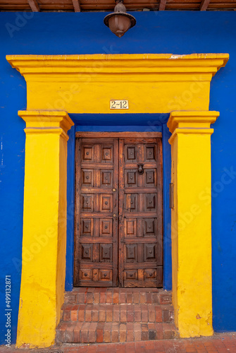 Woodem door in a yellow blue buiding, La  Candelaria, Bogotá, Colombia photo