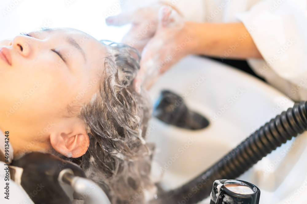 Naklejka premium ヘアサロンでスチームトリートメントを受ける女性