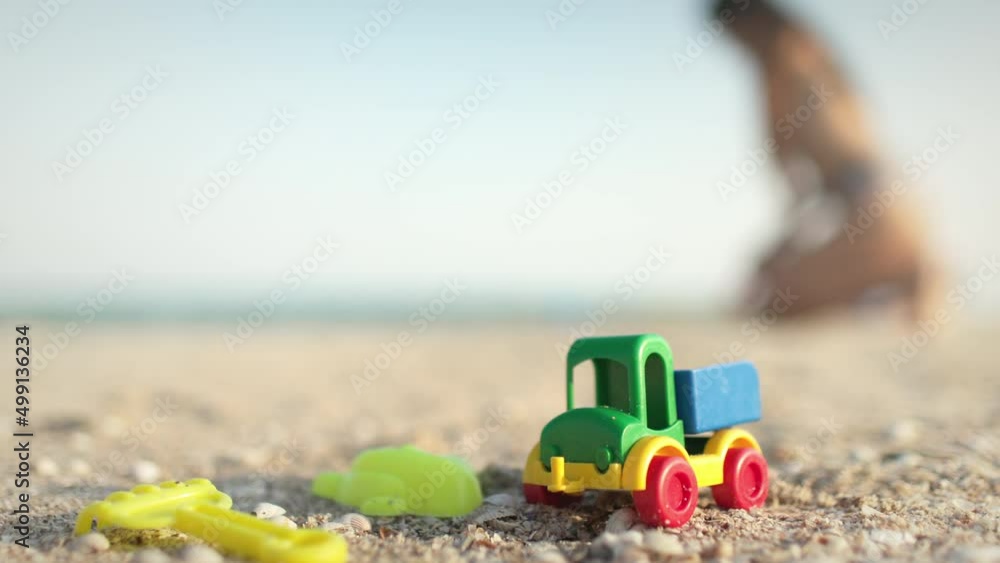 Many toys lie on the beach near the sea under the summer sun Many toys lie on the beach near the sea under the summer sun