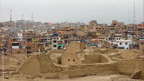 Pachacamac archaeological site, ancient ruins and sanctuary. Poor buildings of city on background. Lima, Peru photo