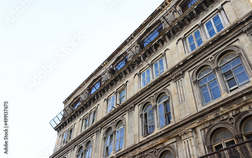 Facade of the old historical building in Istanbul/Fatih. Background of blue sky on a sunny day and gothic style structure with side up perspective angle