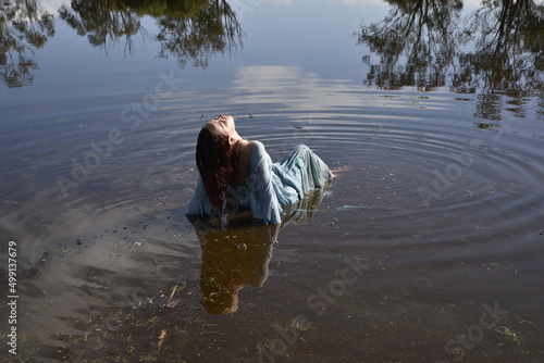 фотографія Portrait of beautiful girl wearing flowing  fantasy gown in a magical lake background