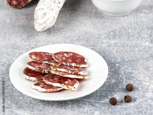 Wallpaper Mural Fuet sausage cut in slices with spices on a light gray background. Traditional Spanish dry-cured pork delicacy with a noble mold Torontodigital.ca