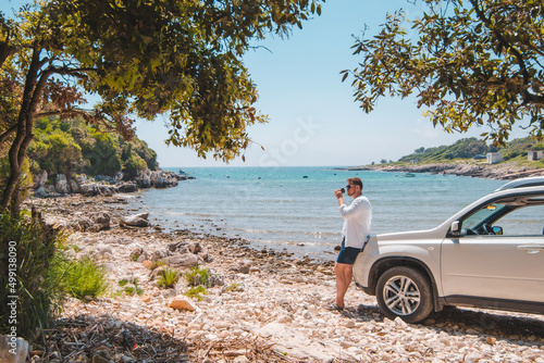 Canvas Print man near white suv car at summer sea beach