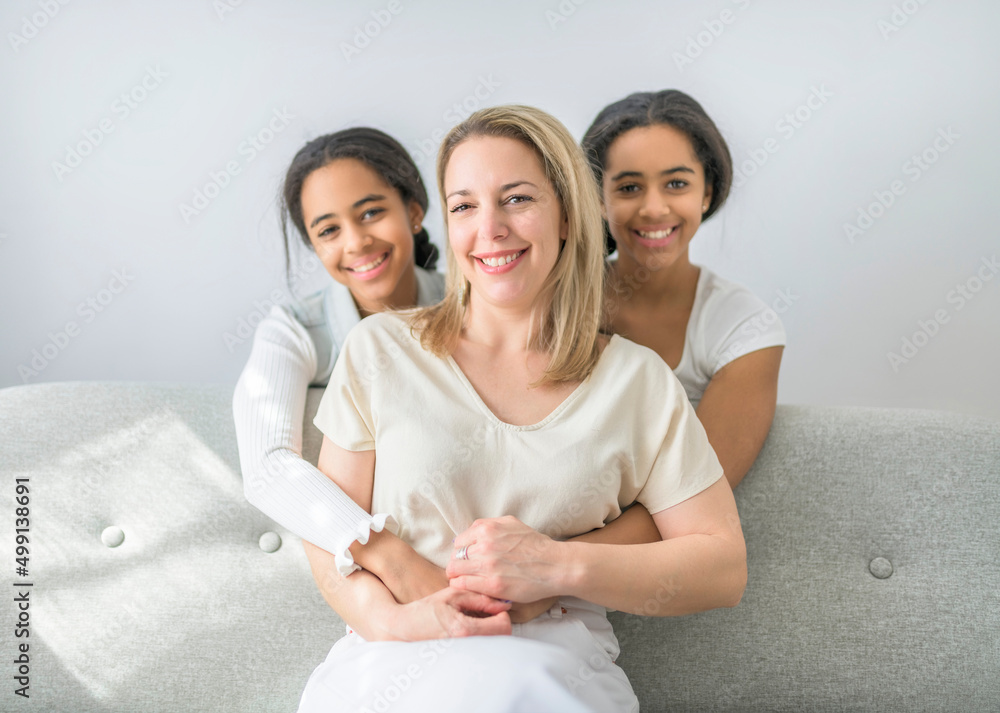 Adorable black twin teen with mother sit on sofa at home Adorable black twin teen with mother sit on sofa at home