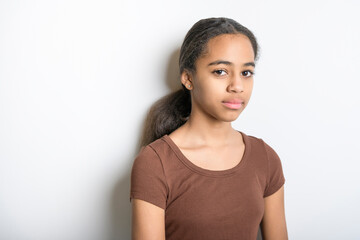 Beautiful black teen posing on studio white background looking sad