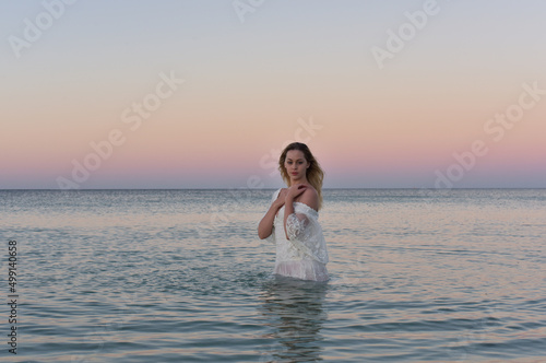 Portrait of beautiful girl wearing flowing fantasy gown in a magical lake background.