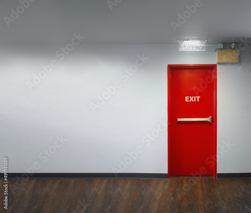 Fire exit door. Fire exit emergency door red color metal material with alarm and emergency light and fire extinguish equipment on building wall for safety protection. Doors for escape conflagration. photo