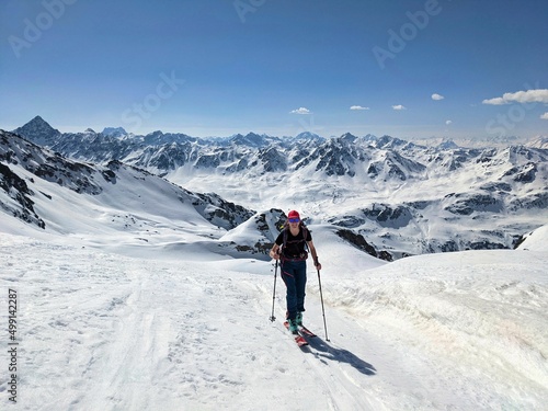 a woman on a ski tour in a wonderful mountain landscape. Freedom and pure passion for ski mountaineering. Above the Fluelatal on the Gorihorn