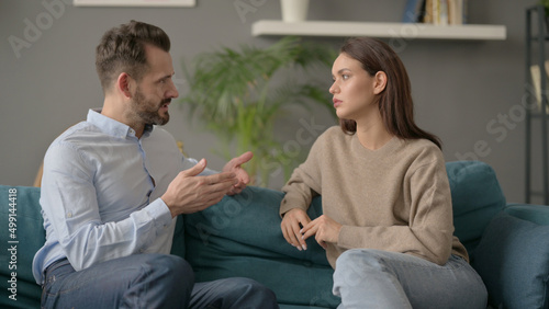 Couple having Serious Conversation while Sitting on Sofa 