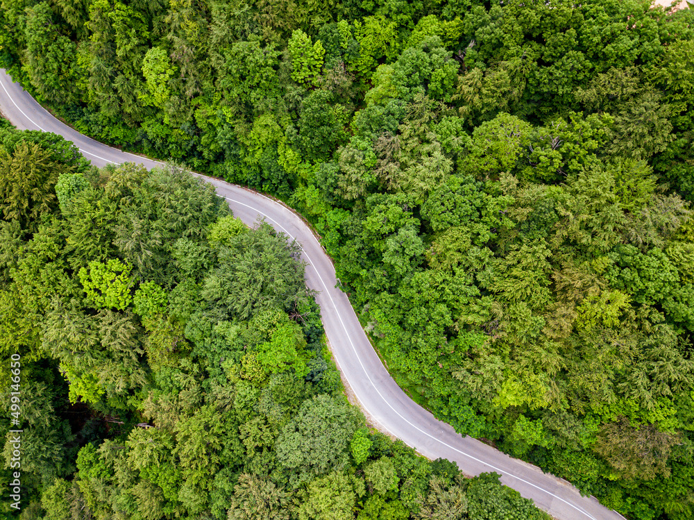 Winding road from high mountain pass, in summer time. Aerial view by drone. Romania