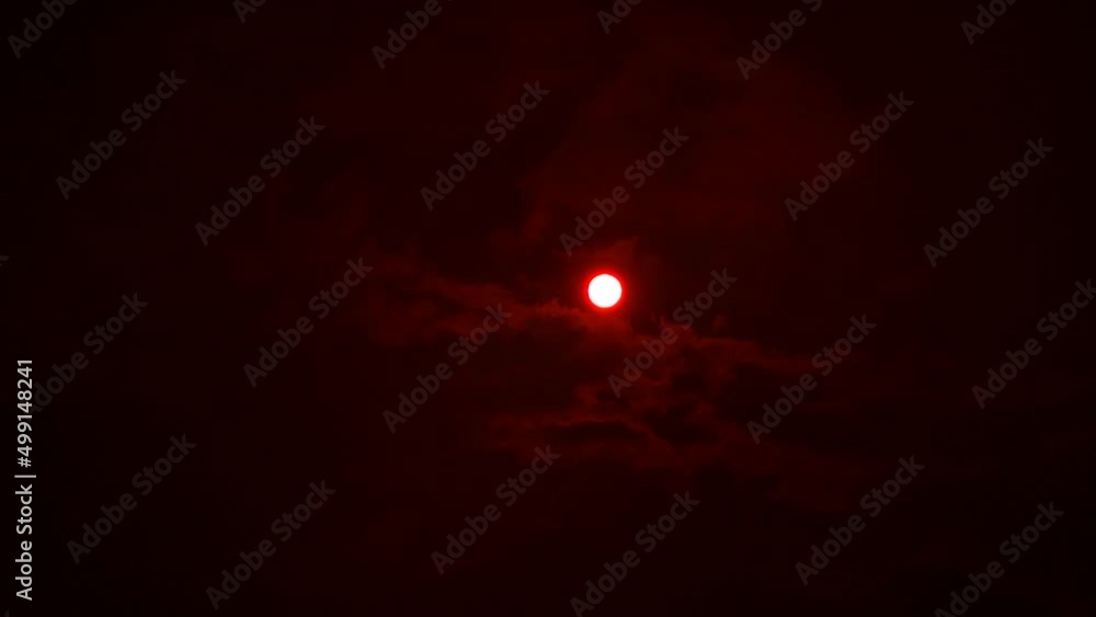 Filming the sun and moving clouds through a red filter