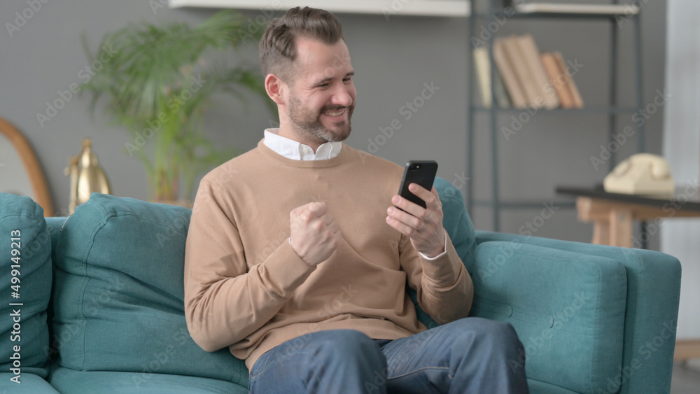 Man having Success on Smartphone at home Man having Success on Smartphone at home