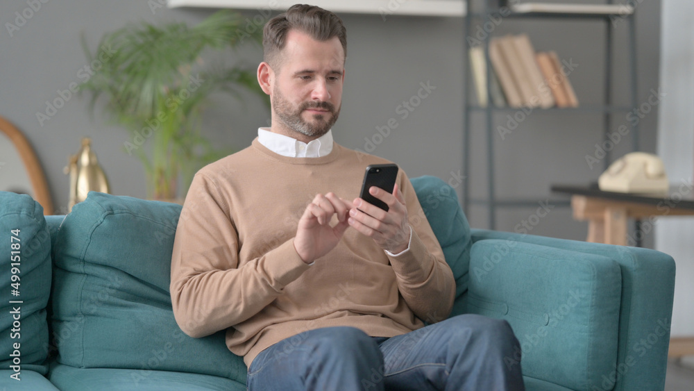 Man using Smartphone on Sofa Man using Smartphone on Sofa