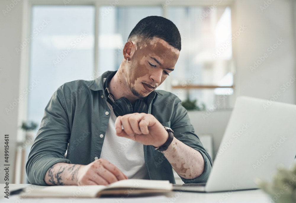 Dont let the fear of losing stop you. Shot of a young business man checking his watch in a modern office. Dont let the fear of losing stop you. Shot of a young business man checking his watch in a modern office.