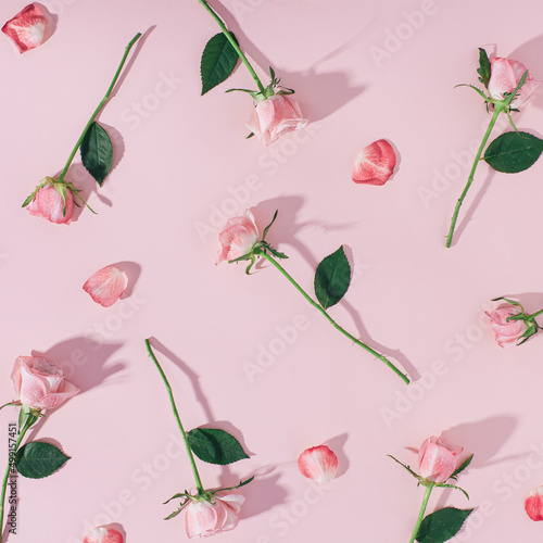 Canvas Print Pink roses and petals laying on pastel pink background