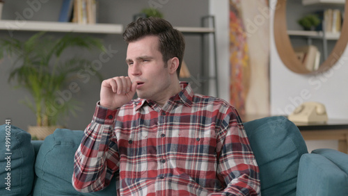 Portrait of Man Coughing while Sitting on Sofa 