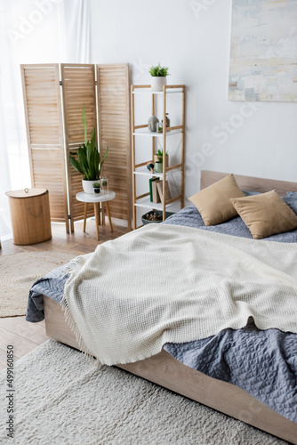 green plants and folding screen in modern bedroom.
