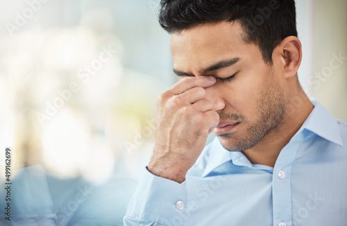 Sometimes challenges arise last minute. Shot of a businessman experiencing a headache at work.