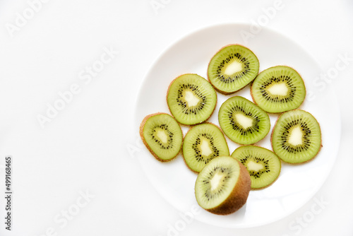 Kiwi fruit sliced on a white plate